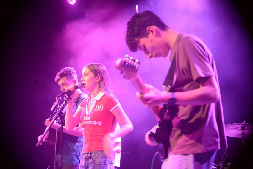Three young people performing in a band