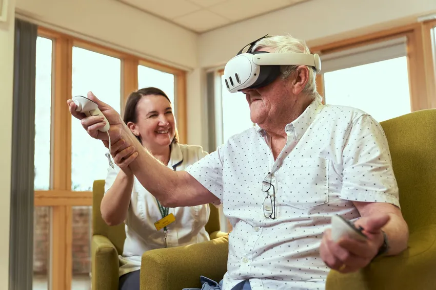Hospice patient using VR headset with support from staff