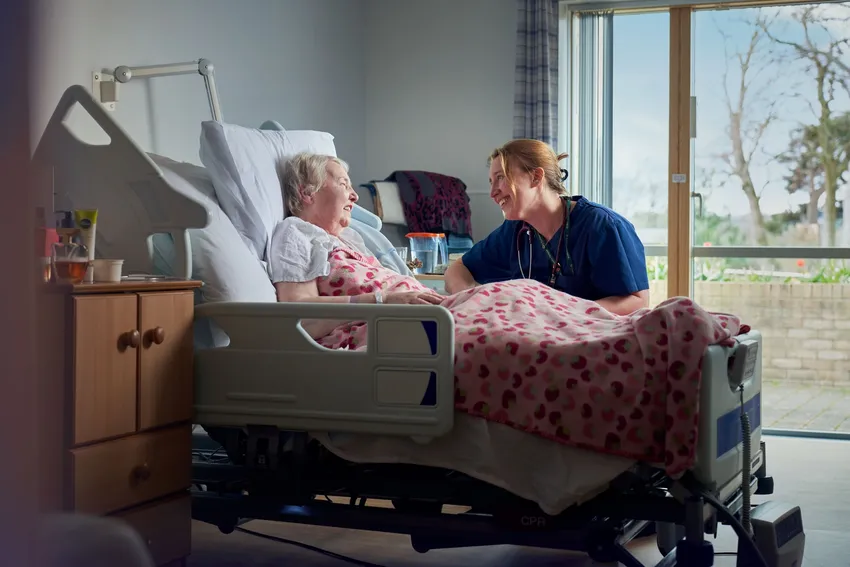 Nurse with hospice patient in bed