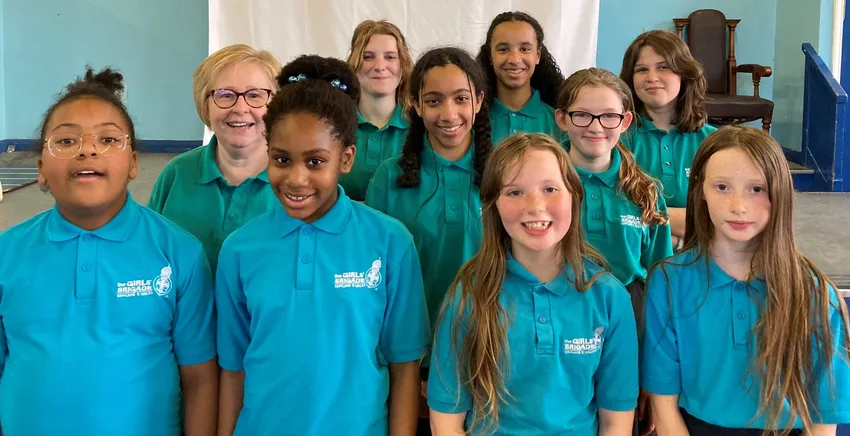 Girls' Brigade members gathered for a group photo with GB volunteer