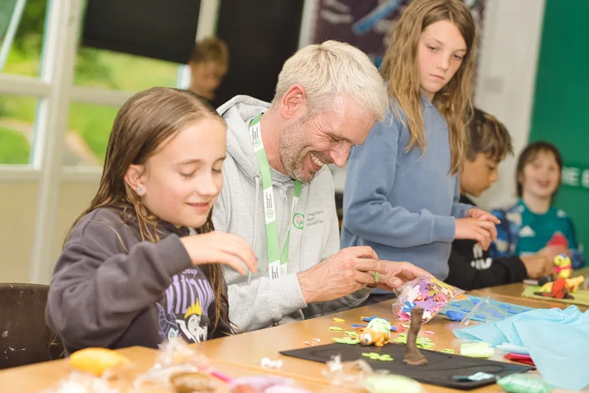 Children enjoy crafts with one of our Youth Workers at our HDYES summer camp