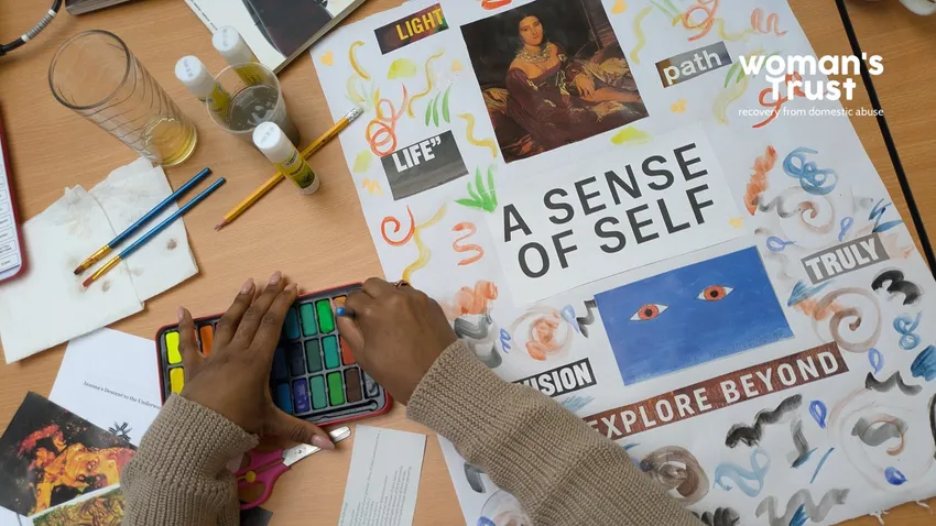 a woman creates a collage as part of her therapeutic work with Woman's Trust