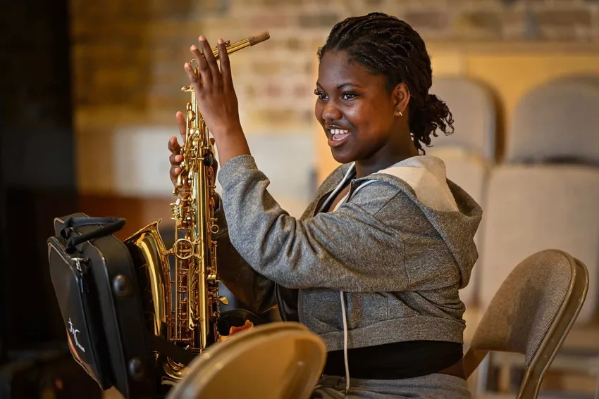 Young person holding saxaphone