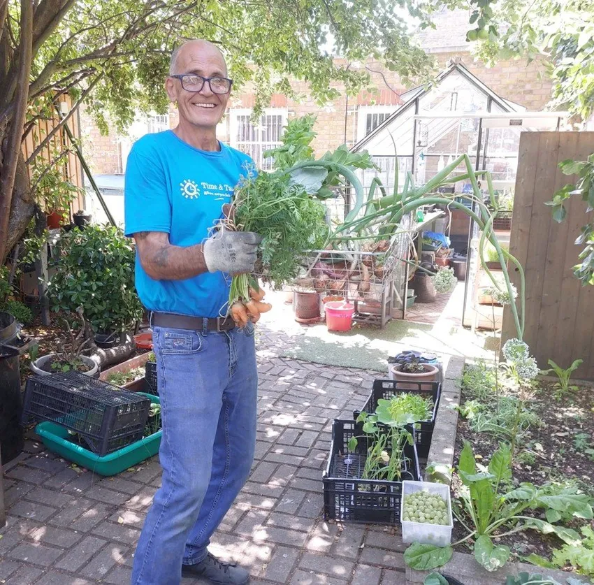 Community Garden - Mick holding baby carrots