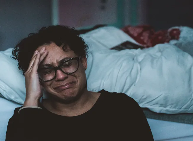 Woman crying next to bed