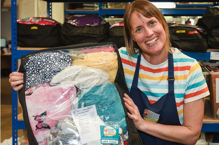Stripey Stork volunteer with a clothing bundle