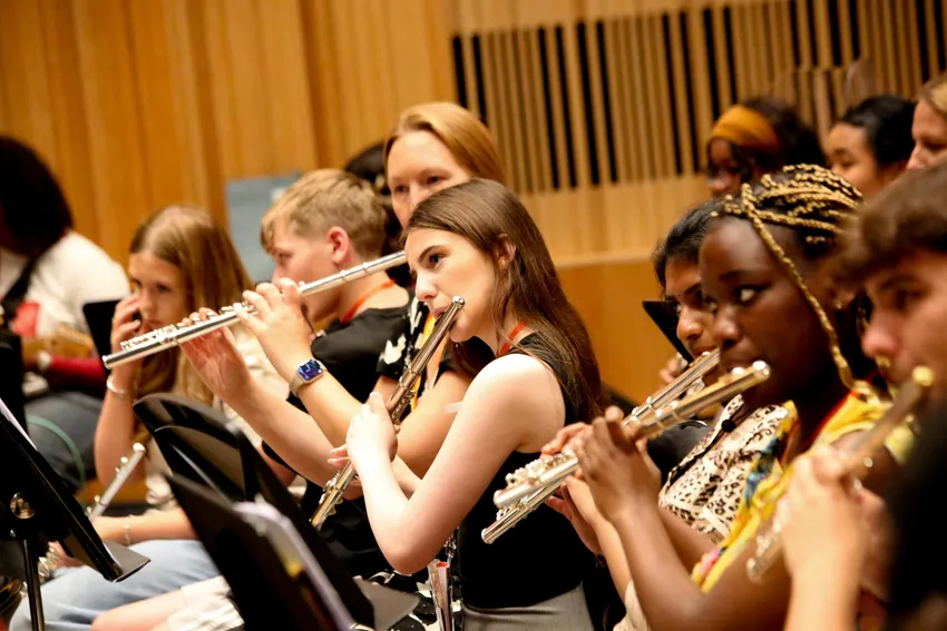 A group of young people playing flutes