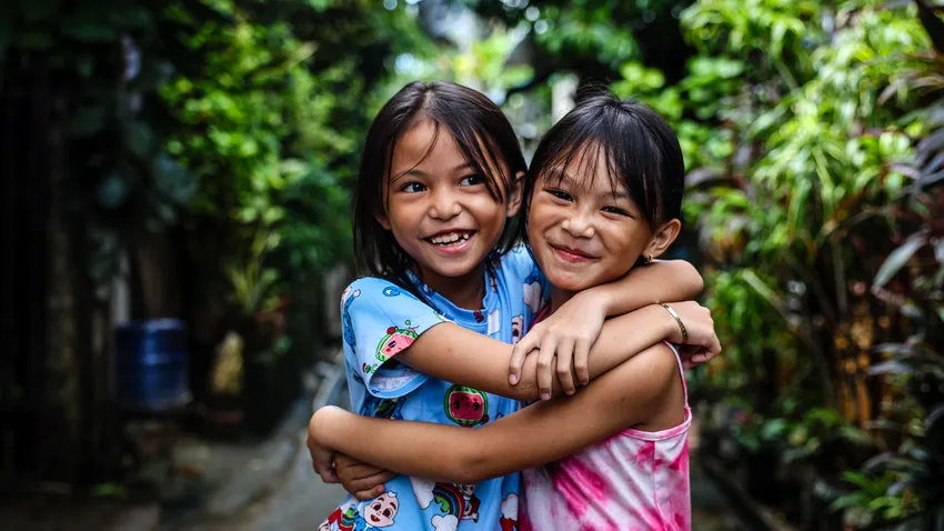 Young friends hug in the Philippines
