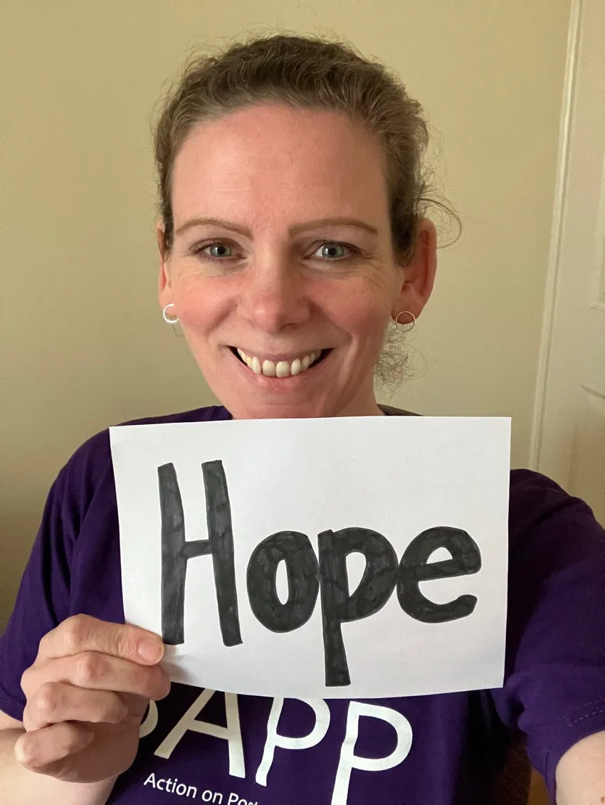 A woman holding a sign saying 'hope'