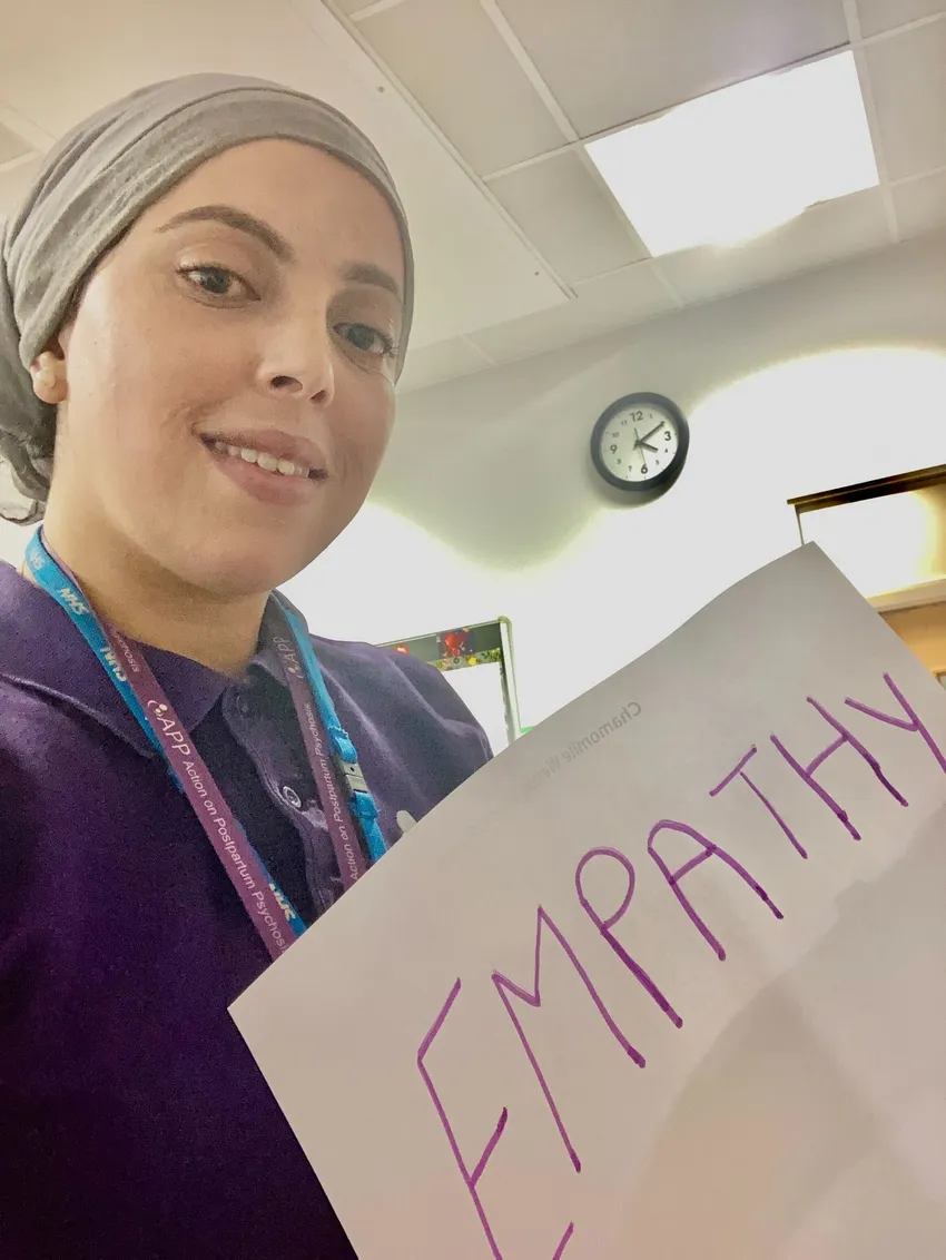 A woman holding a sign saying 'empathy'