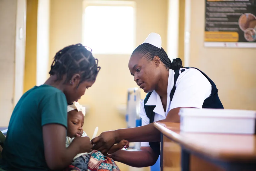 Young mum Patience brings her young child Elizabeth for a weekly health check at ZOA-supported, Twatasha School.