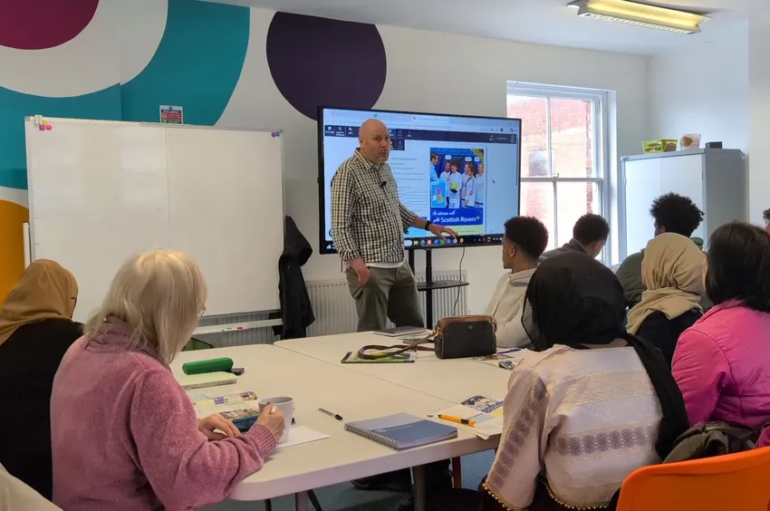 Tutor teaches English to refugees and asylum seekers at our Integration Hub.