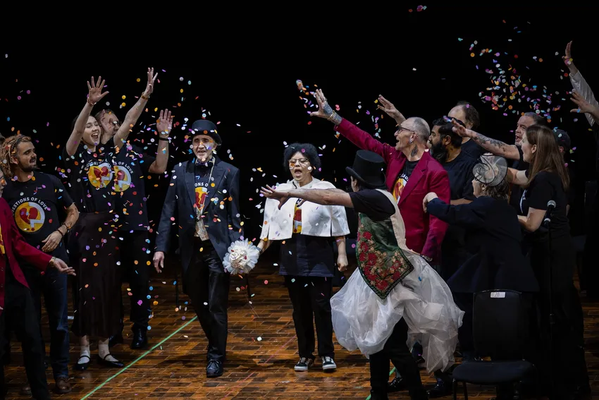 Streetwise Opera performers on stage throwing confetti.