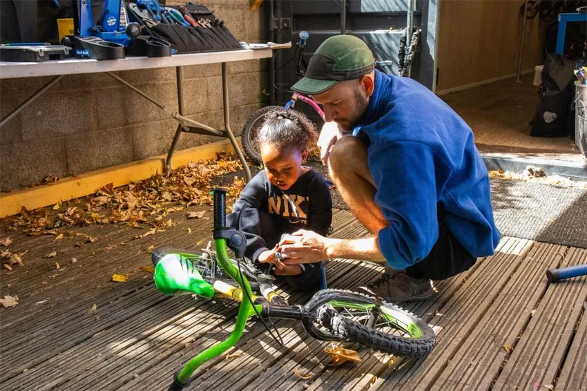 Our youth worker helping a child fix their bike at the youth project.