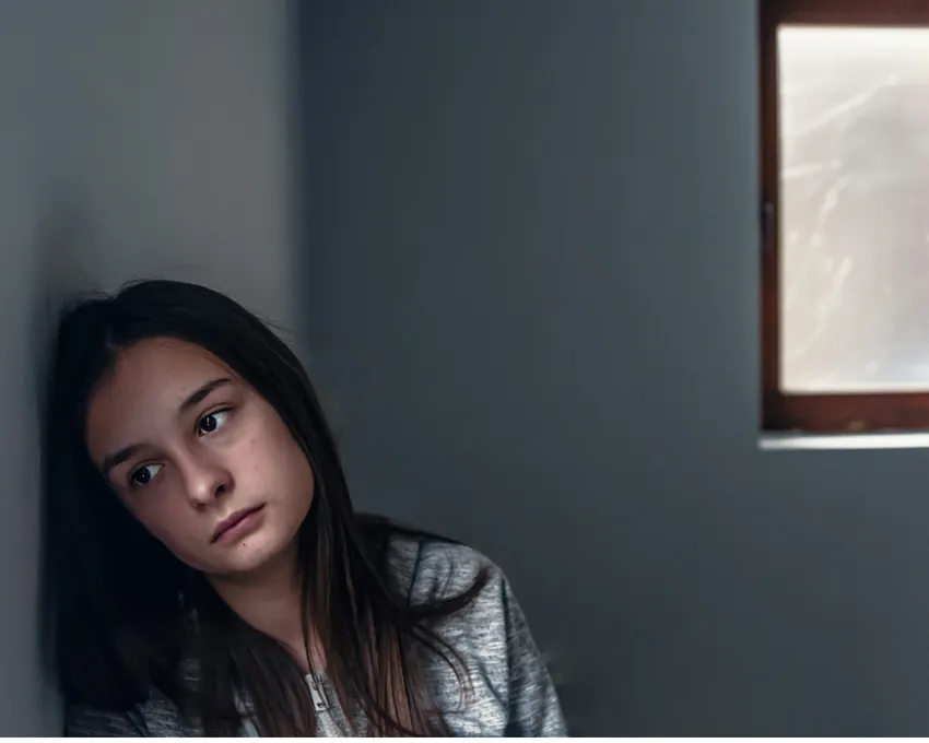 Worried young girl leaning on a wall