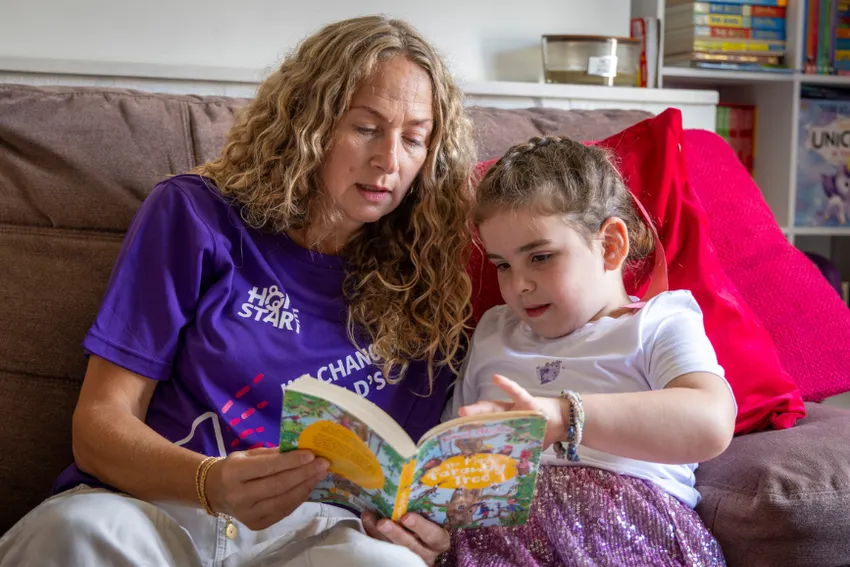 Home-Start volunteer reading with child