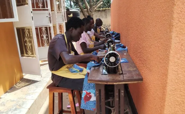 OCA trainees sewing dresses