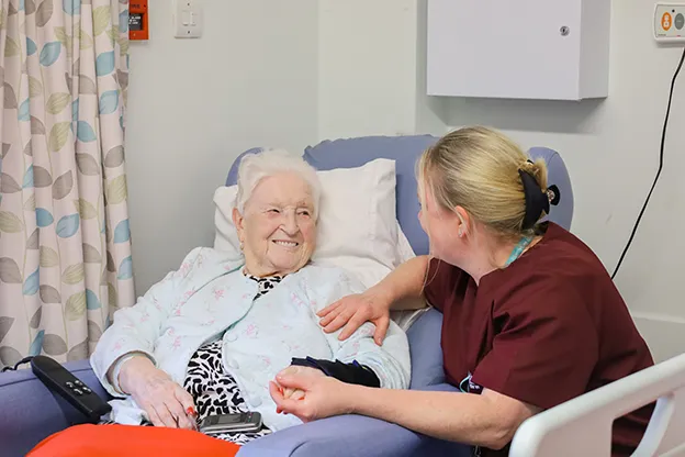 A patient smiles at an Isabel Hospice nurse