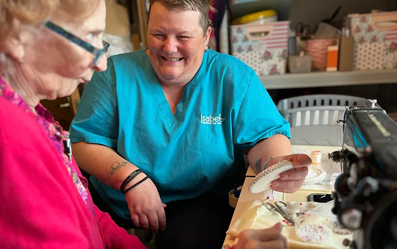 A patient has a playful exchange with an Isabel Hospice community nurse.