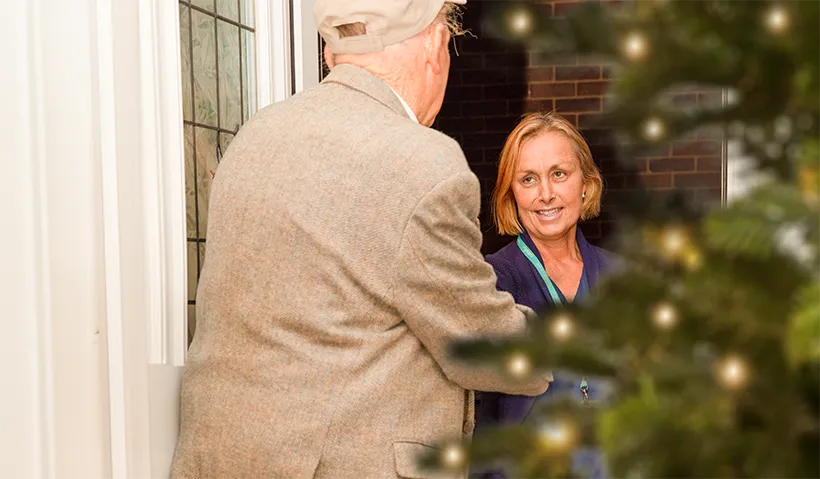 A patient greets an Isabel Hospice community nurse at his front door.