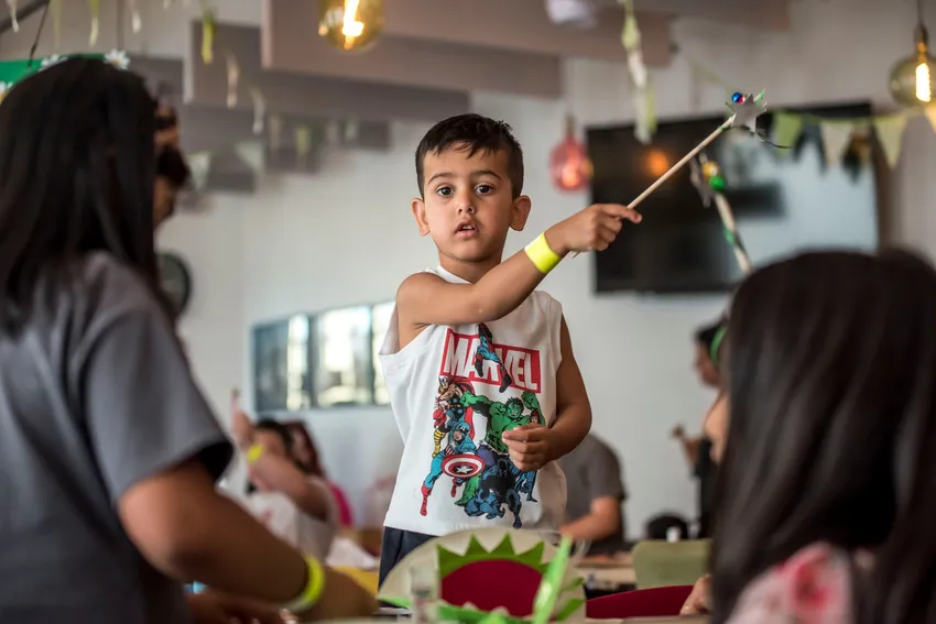 A boy waves a shiny silver wand during an arts and crafts session