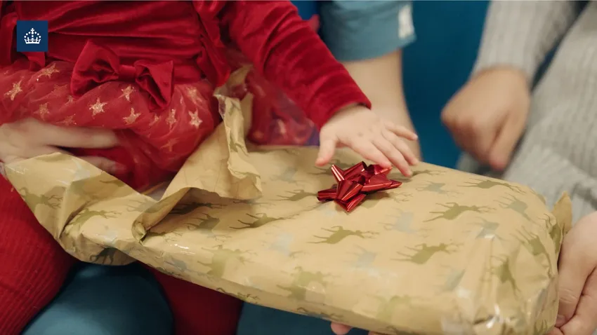 Family Day - Child opening Angel Tree gift in prison