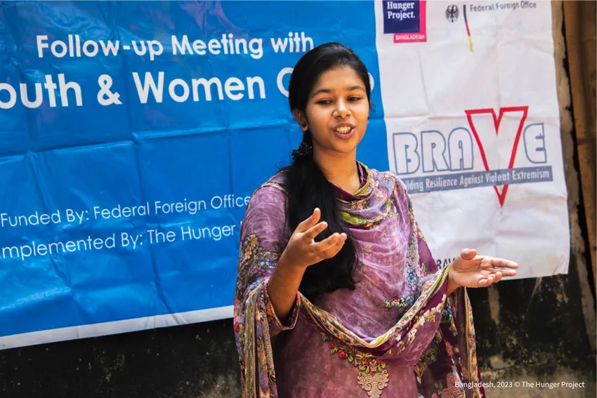A young woman speaking confidently at a Youth and Women Group follow-up meeting in Bangladesh, implemented by The Hunger Project.
