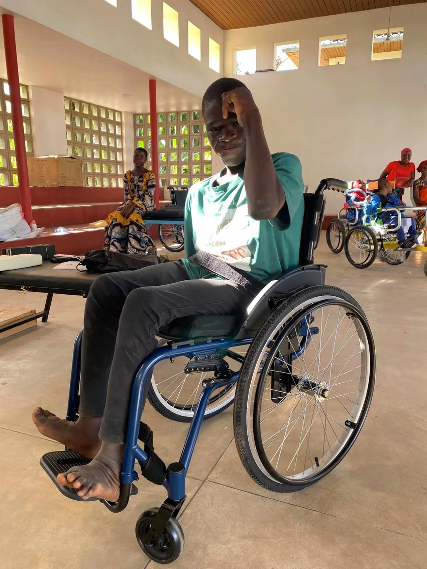 A young man in a wheelchair strikes a muscle flex pose