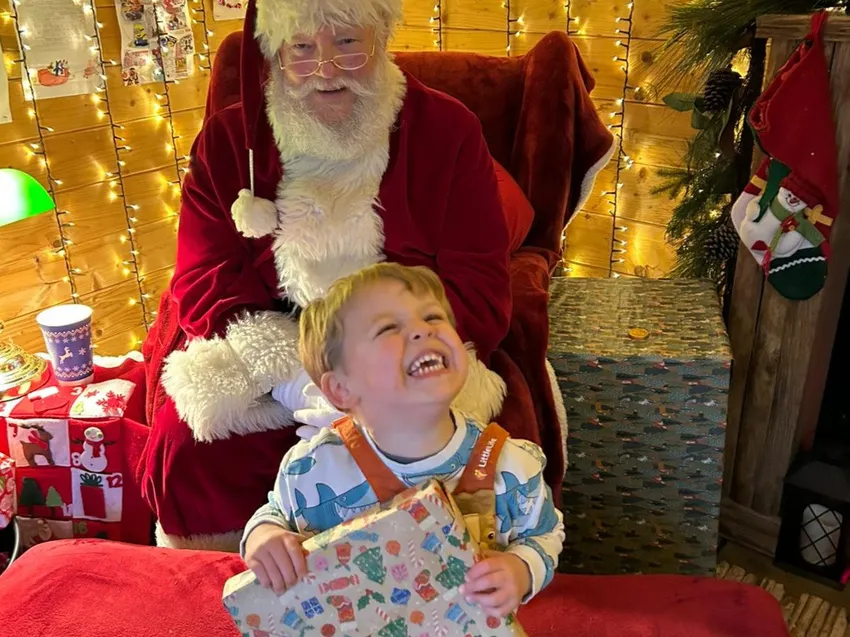 Child receiving a Christmas present from Santa