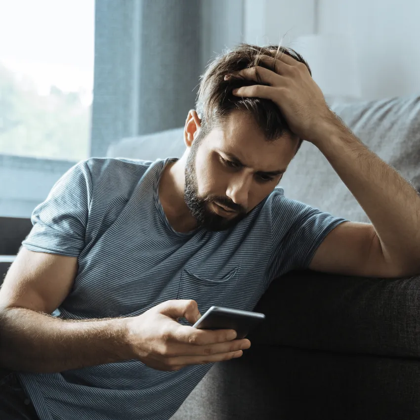 Man looking sad holding phone