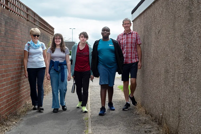 three young carers and two volunteers walking towards the camera