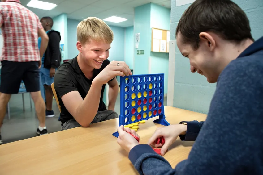 two young carers playing connect four at a youth club