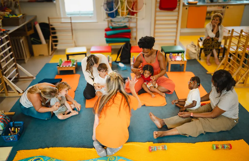 Young children sitting in a group with their parents
