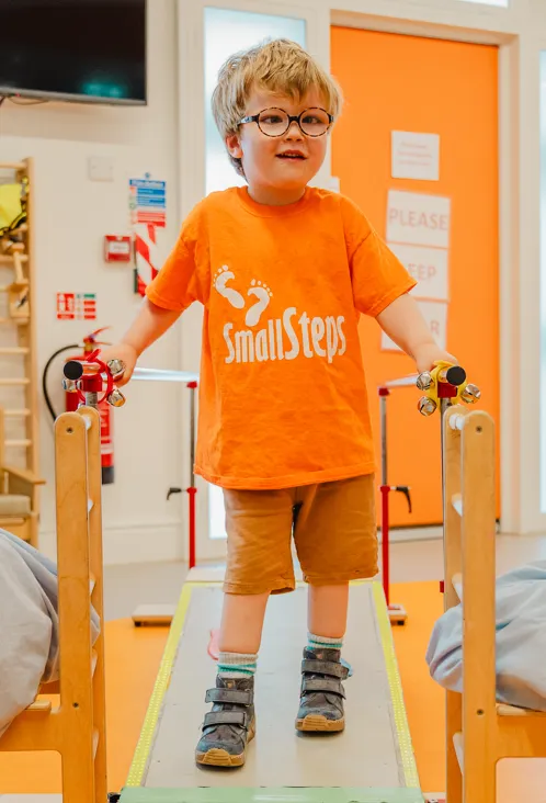 A young boy walking with support