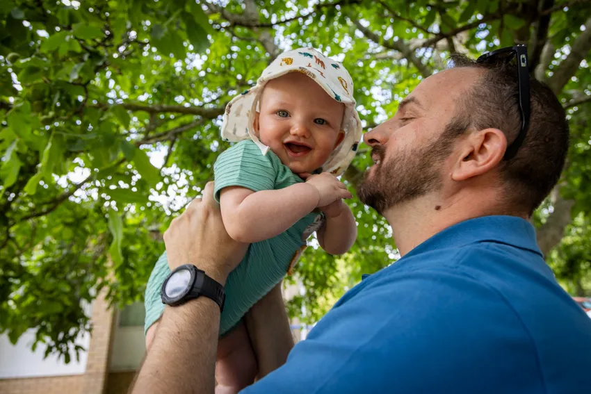 Baby smiling at camera with Dad