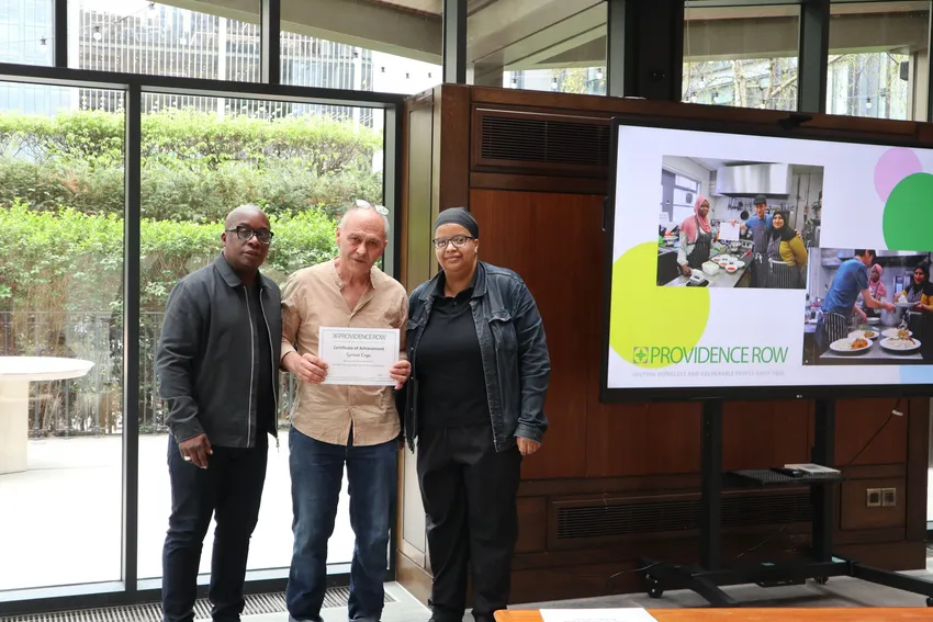 Male client receiving his certificate of completion of our Kitchen Trainee Programme from Providence Row staff members