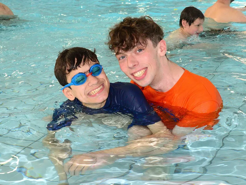 Worker and young person smiling in a swimming pool