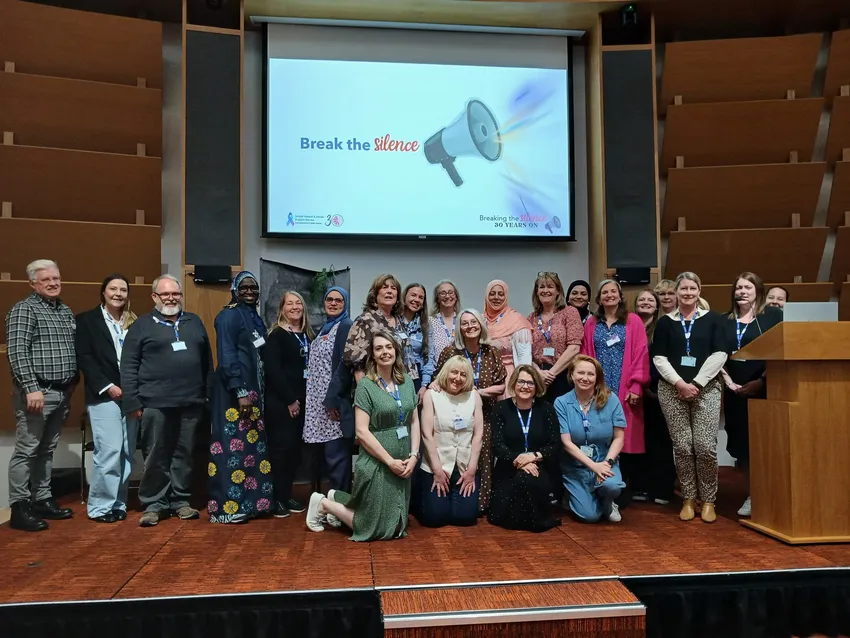 Photo of SAASSBMK staff, trustees and volunteers on a stage