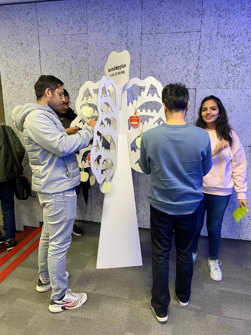 Students at business school hanging paper apples on a Mindapples tree