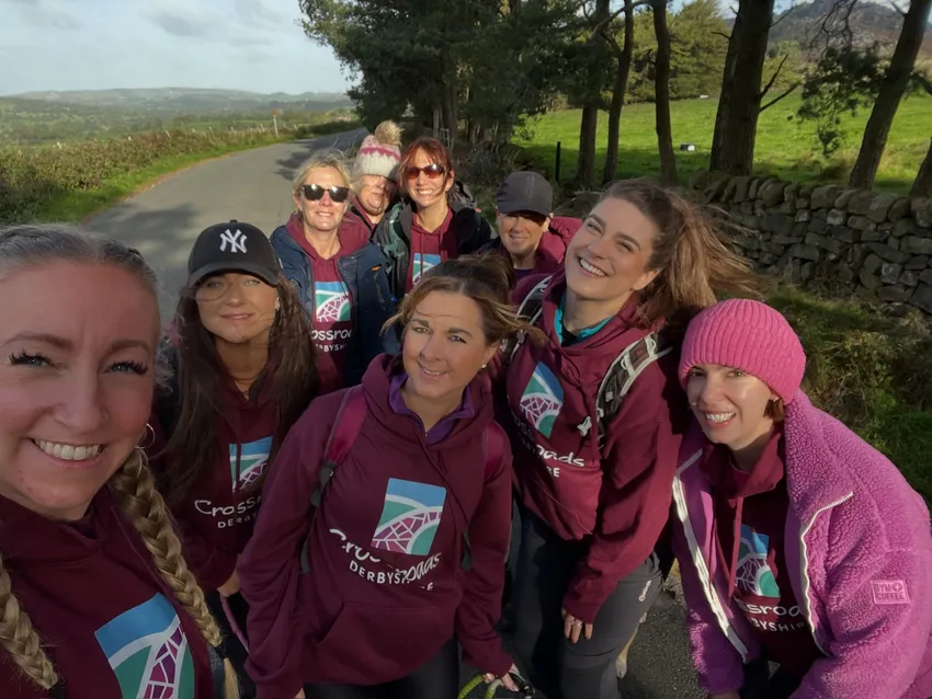 A group of women wearing matching Crossroads Derbyshire hoodies on a sponsored walk in the counrtyside.