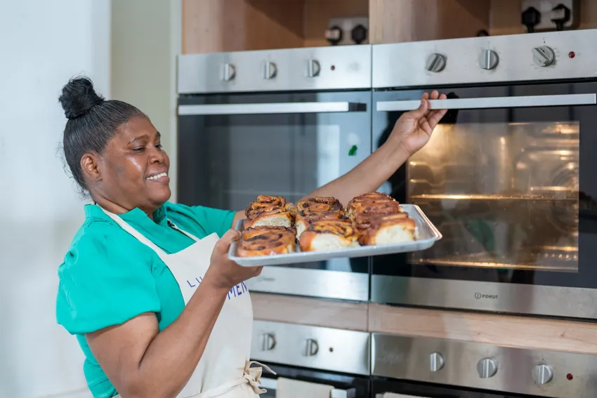Luminary Women taking cinnamon swirls out of the oven