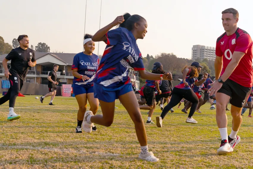 Young people take part in a fun rugby training session on a grass field alongside England Rugby players