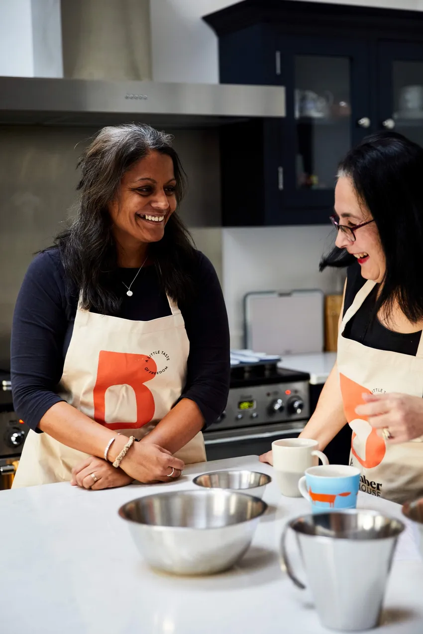 Women at Bramber Bakehouse talking and laughing together whilst baking.