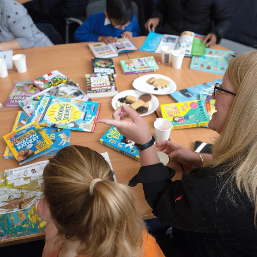 Parents and their children discussing books at one of Learn to Love to Read's books and biscuits events