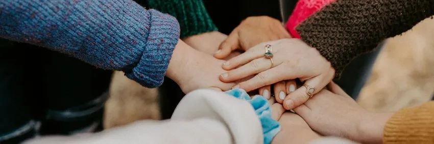 Eight hands stretched out on top of one another.