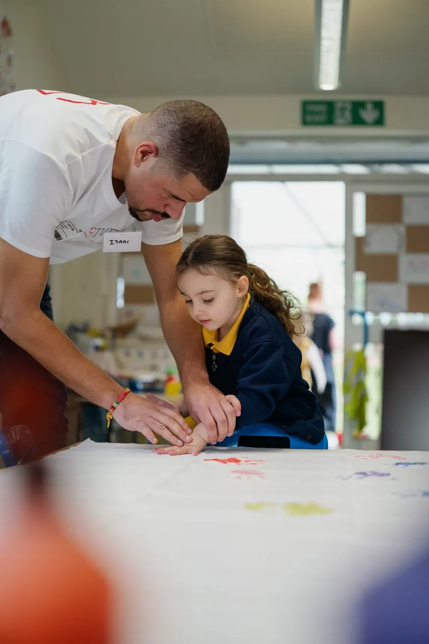 TimeGivers Adult Volunteer supporting young person to paint