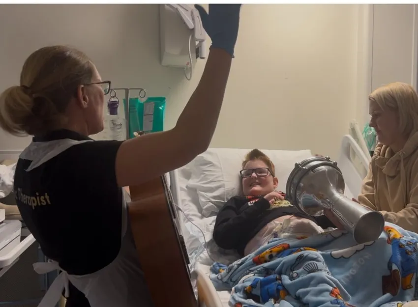 Child smiling having fun in music therapy while in hospital