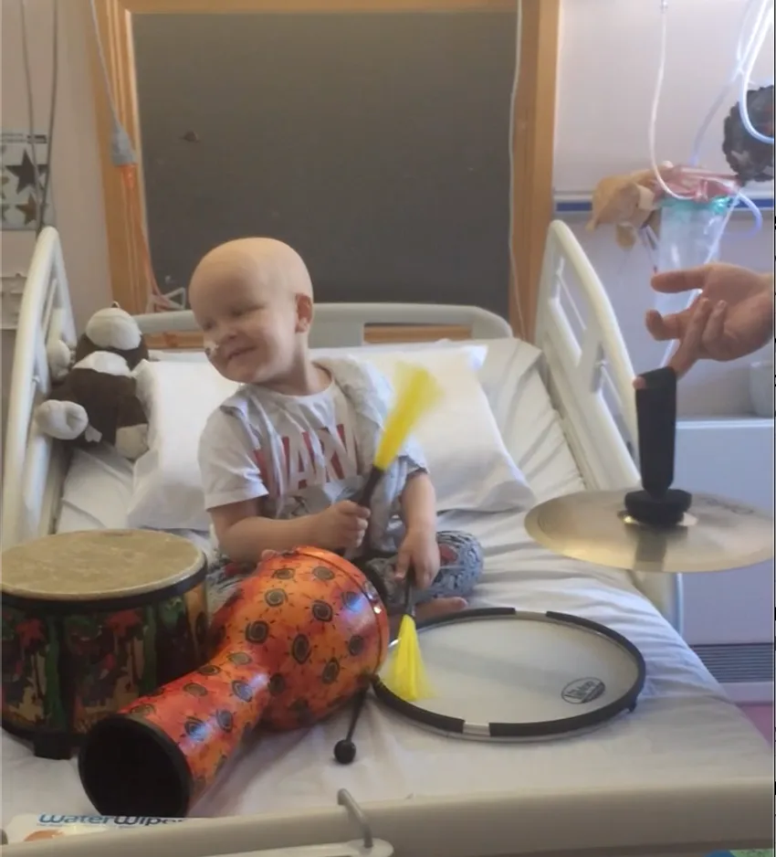 Child smiling in music therapy session in hospital