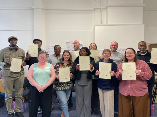 Group of people holding certificates from training with homelessness service providers and service users