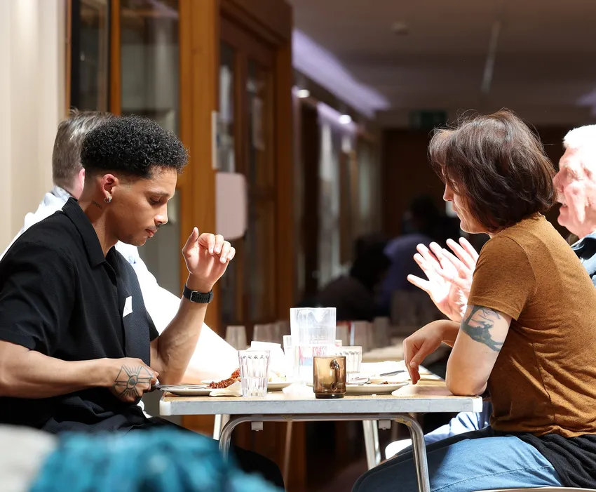 Two people in conversation over a dinner table